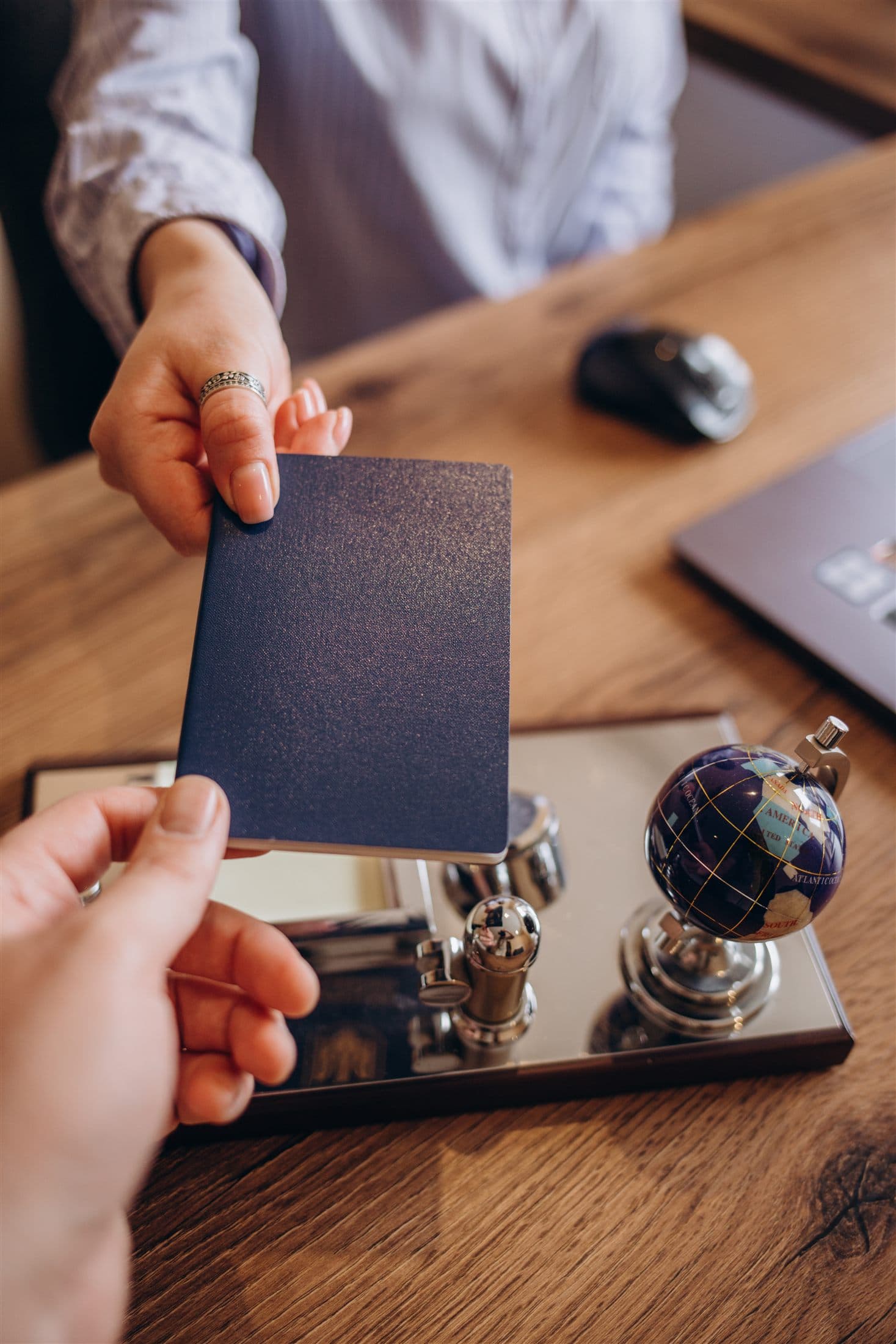 Advisor handing travel documents across a desk during a client meeting.