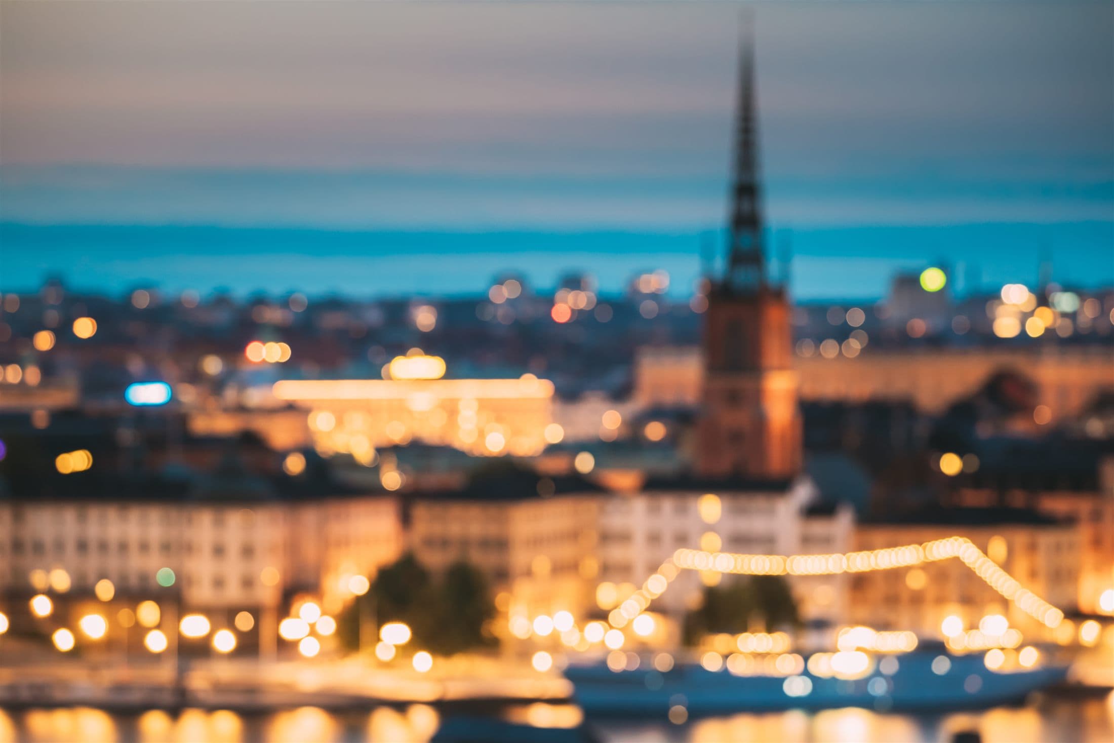Night skyline with warm city lights reflected across the water in Stockholm.